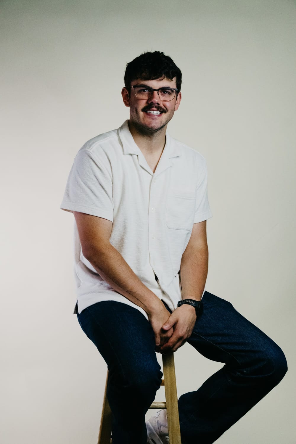Nathaniel Bingham, founder of Grow Your Business Co, seated on a stool